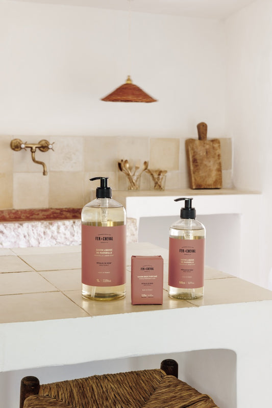Two bottles of soap on a kitchen counter with a neutral color scheme.