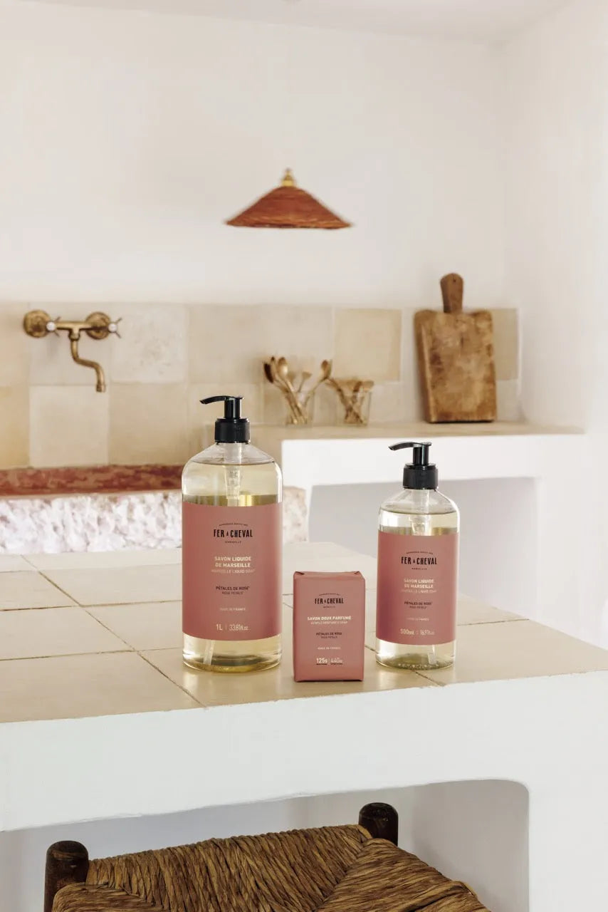 Two bottles of soap on a kitchen counter with a neutral color scheme.