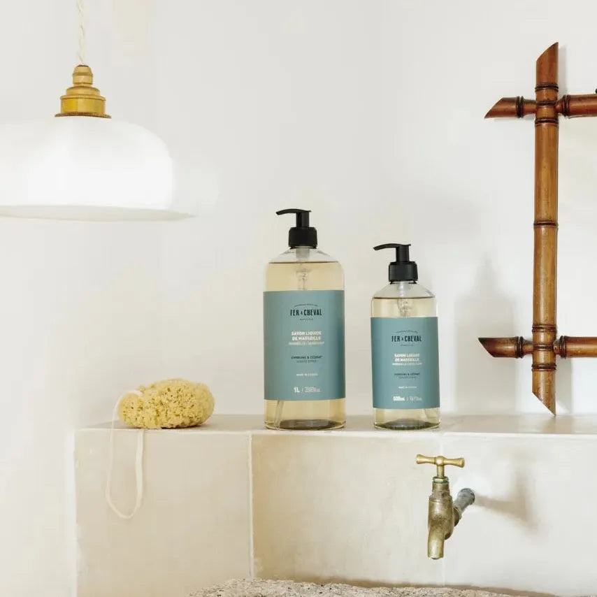 Bathroom setting with two bottles of soap on a shelf, a faucet, and a bath mat.