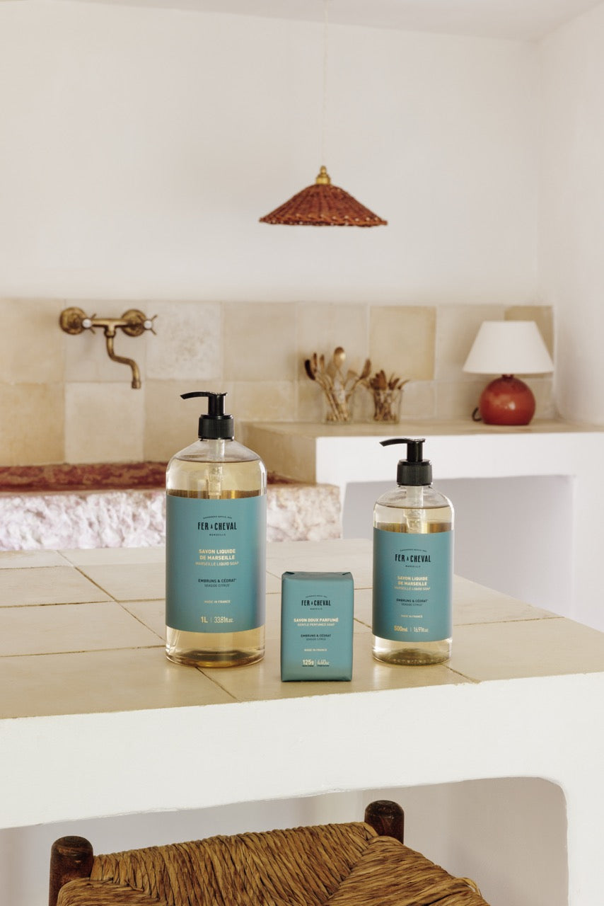 Bathroom setting with two bottles of soap and a small container on a counter.
