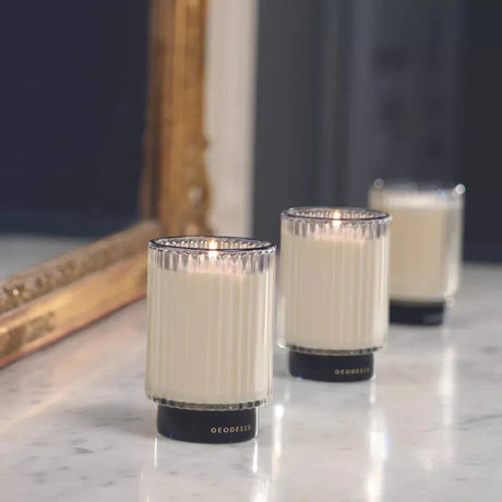 GEODESIS Agar Wood (Oud), Borneo, Fig Tree and Tuberose Prestige Candle on a marble surface with a mirror. by Geodesis French Soaps UK