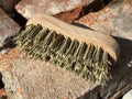Wooden brush with bristles on a rocky surface