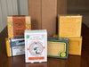 Collection of various Honey Savon de Marseille soaps and packaging on a wooden surface