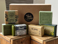 Collection of French soap bars on a wooden surface with 'French Soaps' branding.