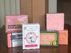Collection of various Rose fragranced French soap bars with different packaging designs on a reflective surface.
