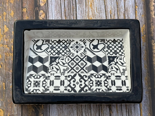 Decorative tray with black and white geometric pattern on a wooden surface