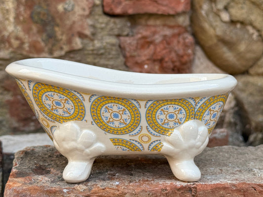Decorative ceramic bathtub with decorative patterns on a stone surface.